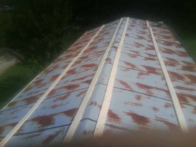Rusted metal roof panels with new wood purlins before replacement — Storm Damage Roof Repair in Methuen by Roofing Brothers