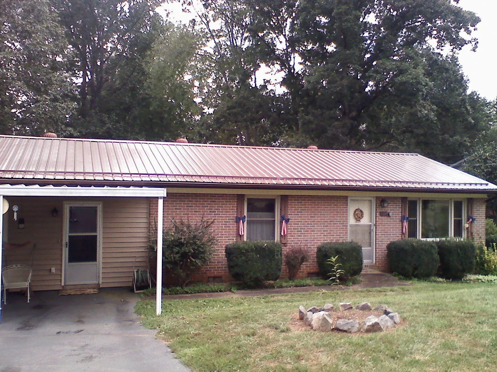 Bronze metal roof and carport on a brick ranch home — Roof Repair work by our crew in Methuen