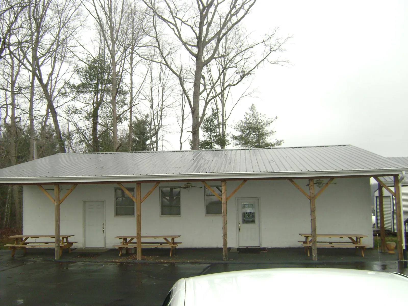 Gray metal roof over a block building with a timber post porch in Methuen